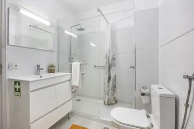 a white bathroom with a toilet and a shower at CoolHouses Algarve Luz, Sunny Luz in Luz