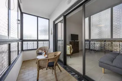 a living room with a table and chairs and windows at CoolHouses Algarve Luz, Sunny Luz in Luz