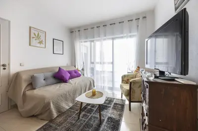 a living room with a couch and a flat screen tv at CoolHouses Algarve Luz, Sunny Luz in Luz