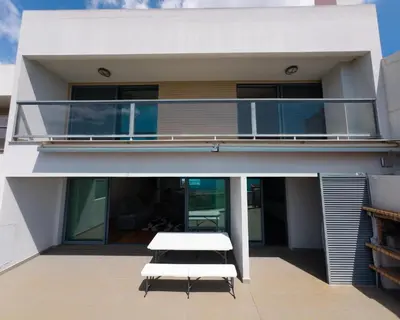 a white bench on the balcony of a house at Moradia Garcês in Santa Cruz