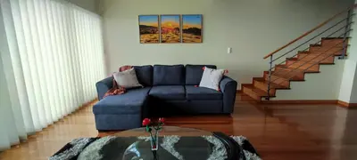 a living room with a blue couch and stairs at Moradia Garcês in Santa Cruz