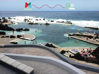 a swimming pool on the beach with people in the water at Moradia Garcês in Santa Cruz