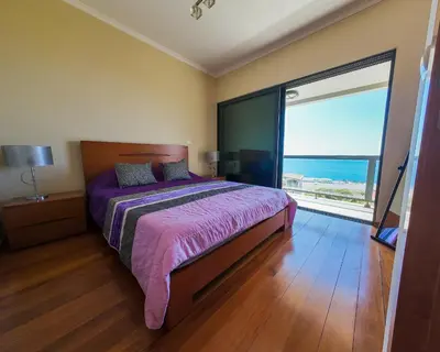 a bedroom with a bed and a large window at Moradia Garcês in Santa Cruz