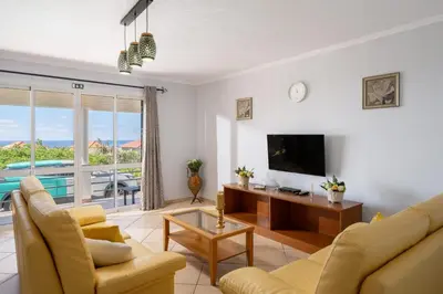 a table with food and wine on a balcony with windows at Gazela House Comfort & Barbecue in Porto Santo in Porto Santo