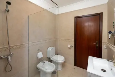 a bathroom with a toilet and a glass shower door at Gazela House Comfort & Barbecue in Porto Santo in Porto Santo