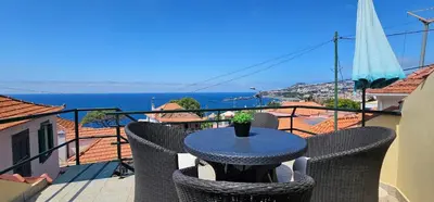a table on a balcony with a view of the ocean at Casa do Juvenal in Funchal