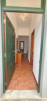 an empty hallway with a green door and a tile floor at Casa do Juvenal in Funchal