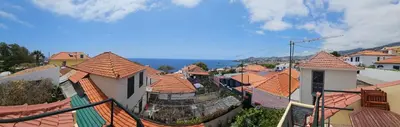 a view of a town with roofs of buildings at Casa do Juvenal in Funchal