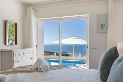 a bathroom with a sink and a shower with a mirror at Casa Maresia da Salema in Salema