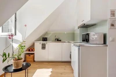 a kitchen with white cabinets and a staircase at Nati by KAAMAH in Ribeira Brava