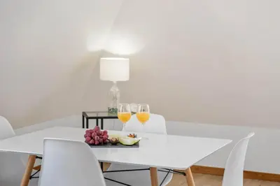 a white dining room table with two glasses of wine at Nati by KAAMAH in Ribeira Brava