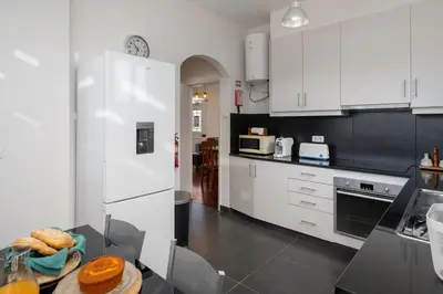 a kitchen with white appliances and a table with bread on it at Vivenda do Moinho Refuge in Porto Santo in Porto Santo