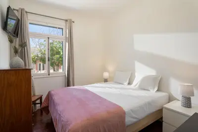 a white bedroom with a bed and a window at Vivenda do Moinho Refuge in Porto Santo in Porto Santo