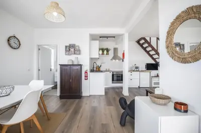 a kitchen and living room with white walls and wooden floors at Blue House - By WehostMadeira in Ponta do Sol
