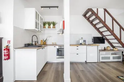 a kitchen with white cabinets and a staircase at Blue House - By WehostMadeira in Ponta do Sol