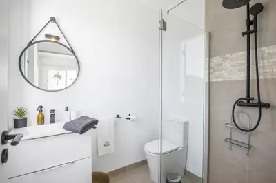 a bathroom with a toilet and a glass shower at Blue House - By WehostMadeira in Ponta do Sol