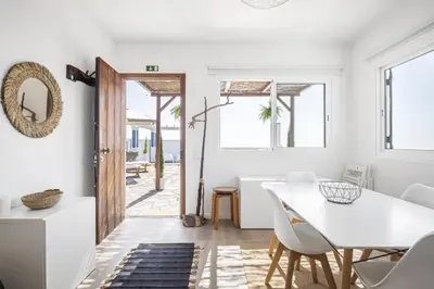a white dining room with a white table and chairs at Blue House - By WehostMadeira in Ponta do Sol