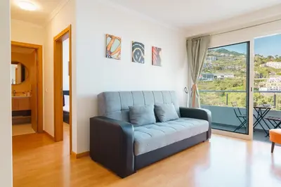 a living room with a couch and a large window at GuestReady - Calm Haven in Madeira in Caniço