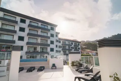 an apartment building with a balcony with lounge chairs at GuestReady - Calm Haven in Madeira in Caniço