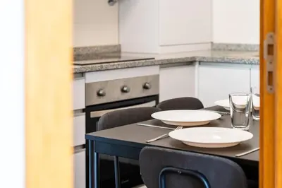 a kitchen with a table with chairs and plates on it at GuestReady - Calm Haven in Madeira in Caniço