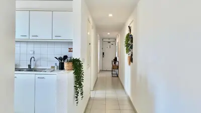 a white kitchen with white cabinets and a window at MaraHomes in Funchal