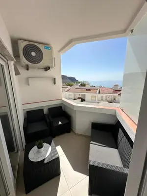 a room with a balcony with a view of the ocean at Sunrise Luz Apartament in Luz