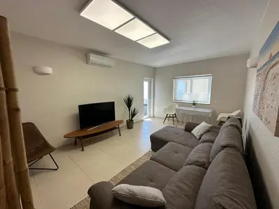 a living room with a couch and a television at Sunrise Luz Apartament in Luz