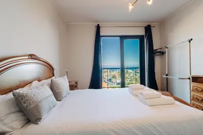 a bedroom with a bed and a large window at GuestReady - Homely stay in Funchal in Funchal