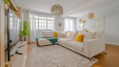 a living room with a white couch and a tv at Family House in Campanário