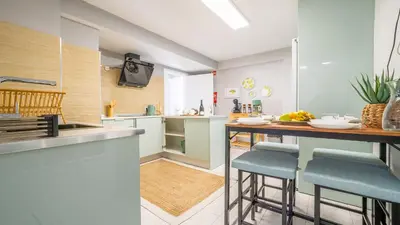 a kitchen with a counter and stools in it at Family House in Campanário
