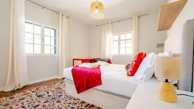 a bedroom with a large white bed with red pillows at Family House in Campanário