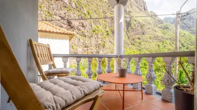 a balcony with a table and chairs and a mountain at Family House in Campanário