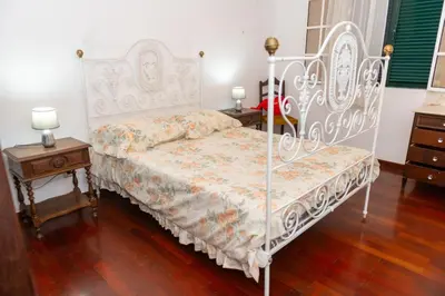 a bedroom with a white bed and two night stands at Bela AL in Funchal