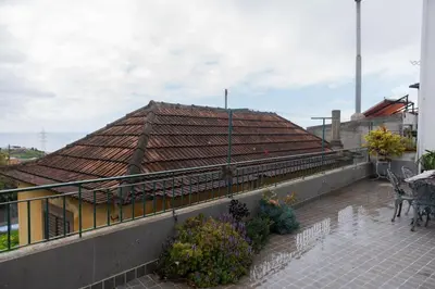 a house with a tile roof with a patio at Bela AL in Funchal