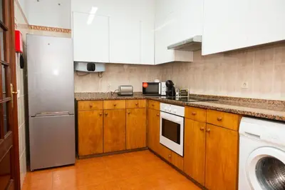 a kitchen with white cabinets and a stainless steel refrigerator at Bela AL in Funchal