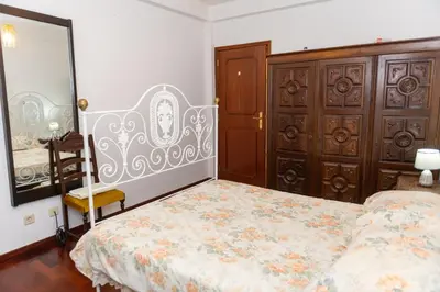 a bedroom with a bed and a wooden cabinet at Bela AL in Funchal