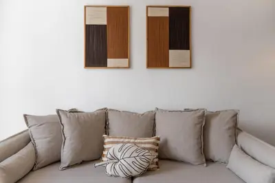 a gray couch with pillows and three pictures on the wall at Quebra Costas I by An Island Apart in Funchal