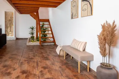 a living room with a chair and a staircase at Quinta da Amoreira in Barão de São Miguel