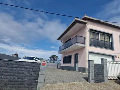 a white car parked in front of a house at Prazeres - Madeira Inn Group in Prazeres