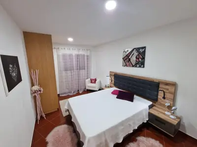 a bedroom with a large white bed and a window at Prazeres - Madeira Inn Group in Prazeres