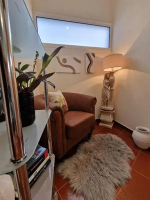 a living room with a chair and a rug at Prazeres - Madeira Inn Group in Prazeres
