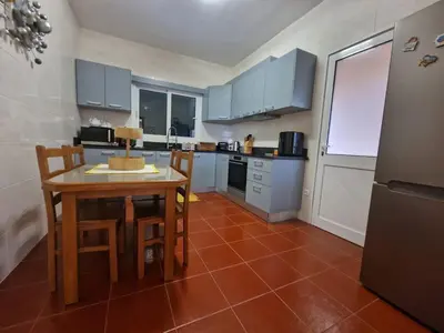 a kitchen with a table and chairs in a kitchen at Prazeres - Madeira Inn Group in Prazeres