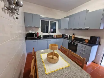 a kitchen with blue cabinets and a table with chairs at Prazeres - Madeira Inn Group in Prazeres