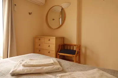 a bedroom with a bed with a mirror and a chair at Luz dream apartment 22G above beach in Luz