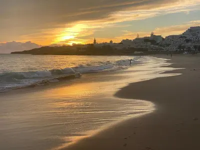 a beach with a person walking in the water at Luz dream apartment 22G above beach in Luz