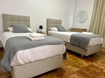 a bedroom with two beds and a mirror at Anita & Leonel's House B in Gaula