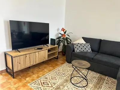 a living room with a couch and a flat screen tv at Anita & Leonel's House B in Gaula
