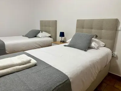 a bedroom with two beds and a table with a lamp at Anita & Leonel's House B in Gaula