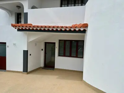 a white building with a red roof and a door at Anita & Leonel's House B in Gaula