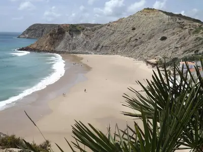 a beach with people on the sand and the ocean at Burgau Ocean View Apartment in Burgau